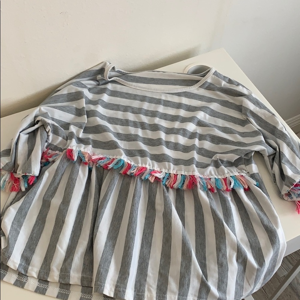 gray and white shirt with tassels